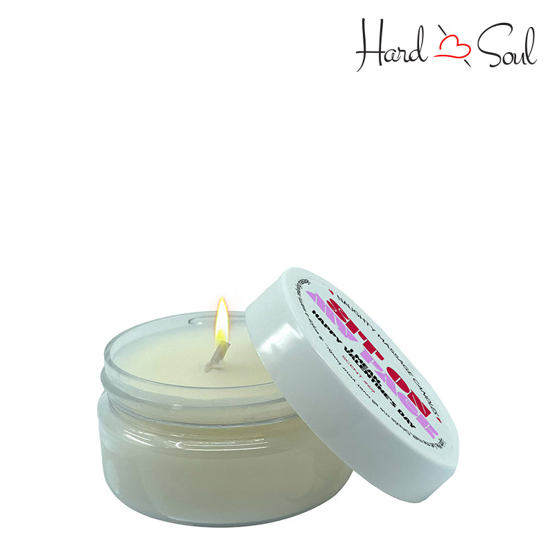 White Jar of Naughty Massage Candle Sit on My Face 1.7oz with the lid partially off, showing the candle lit inside - HardnSoul