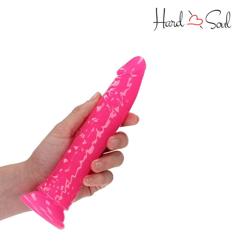 A Hand holding RealRock Glow in the Dark 7 Inch Slim Dildo Pink - HardnSoul