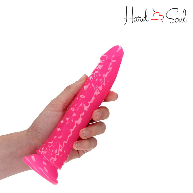 RealRock Glow in the Dark 8 Inch Slim Dildo Pink in a hand - HardnSoul